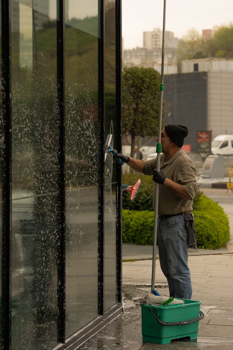 Purified water-fed pole cleaning an upper-story window in Watsonville