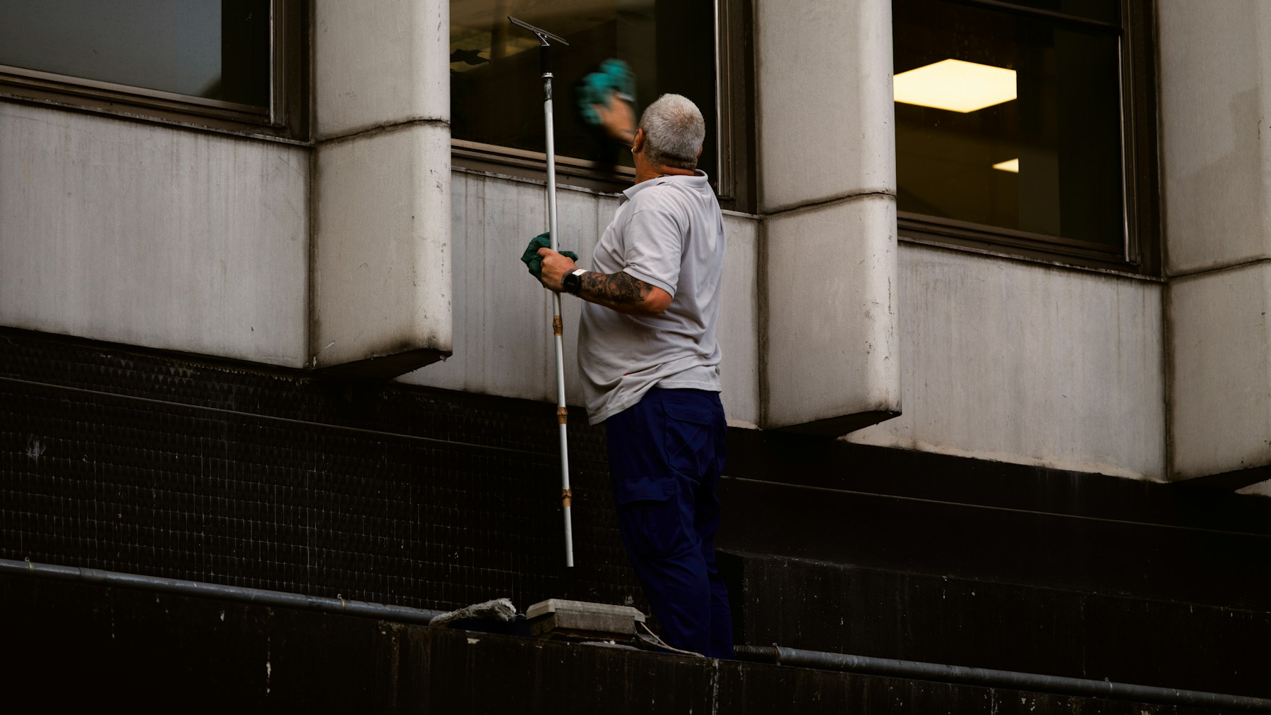 Dane Anderson Window Cleaning technician washing a residential window